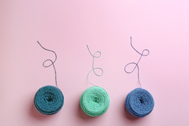 Photo of Clews of knitting threads on color background, flat lay with space for text. Sewing stuff