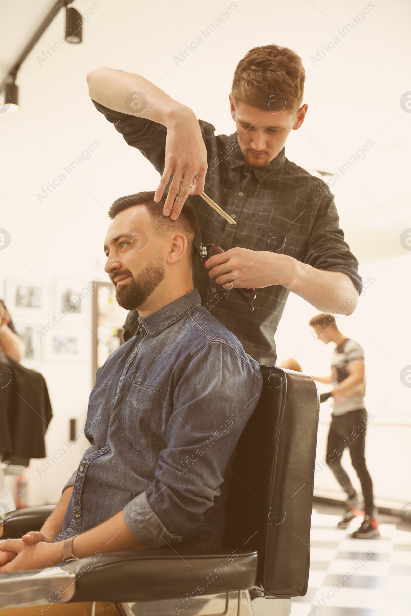 Photo of Professional barber working with client in hairdressing salon. Hipster fashion