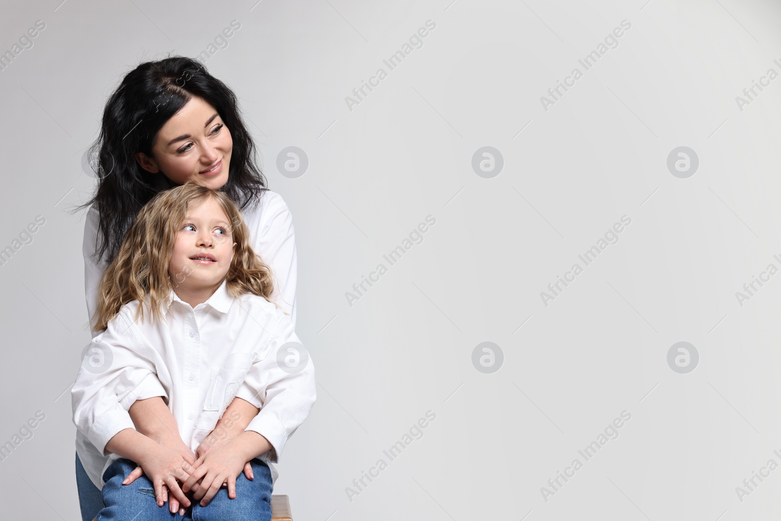 Photo of Beautiful mother with little daughter on white background. Space for text