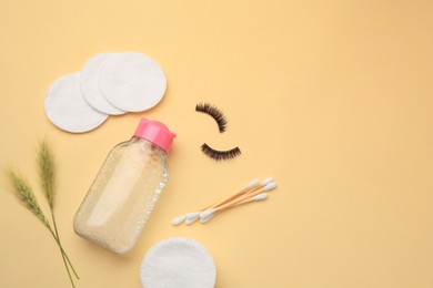 Flat lay composition with makeup removal tools, spikelets and false eyelashes on yellow background. Space for text