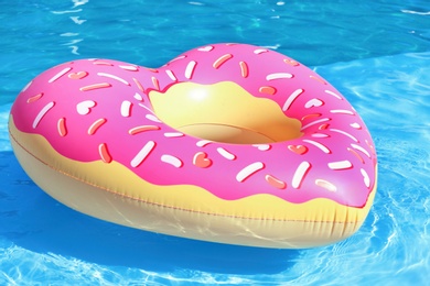 Photo of Heart shaped inflatable heart floating in swimming pool on sunny day