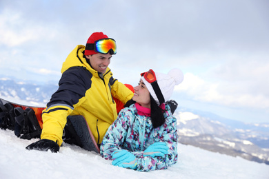 Lovely couple on snowy hill. Winter vacation