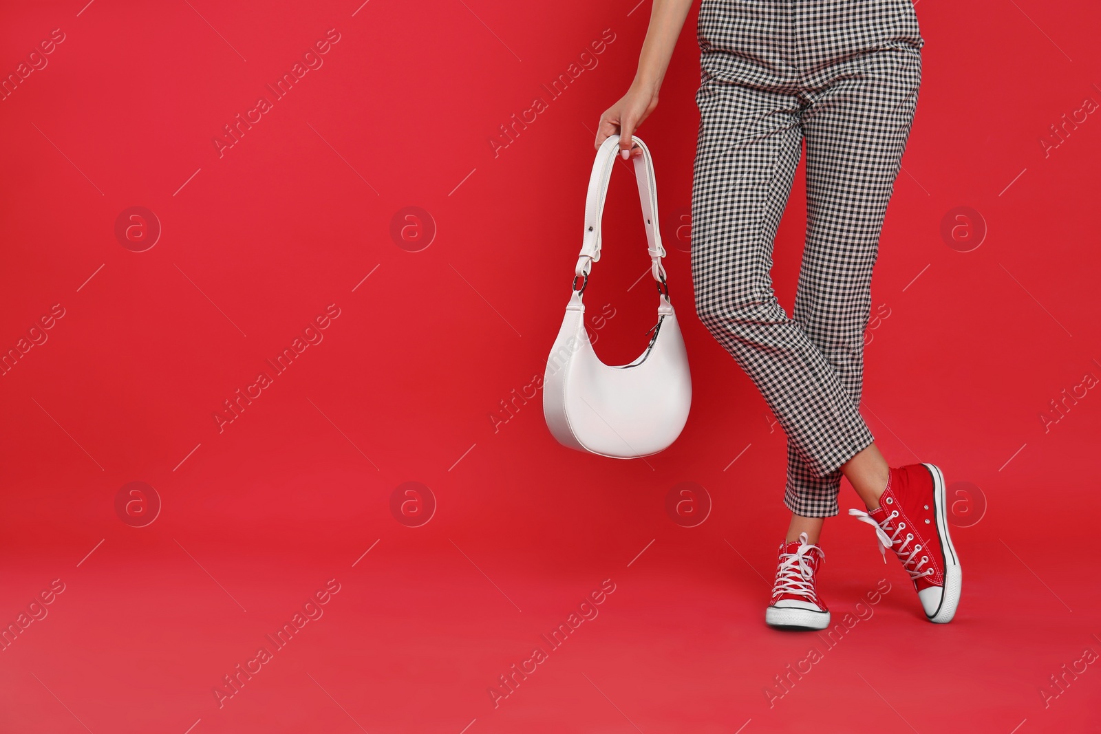 Photo of Woman with stylish bag on red background, closeup. Space for text