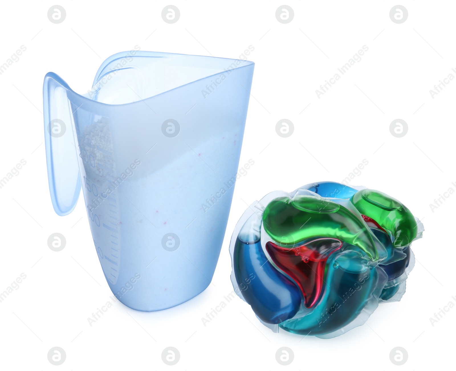 Photo of Laundry capsules and measuring cup of washing powder on white background