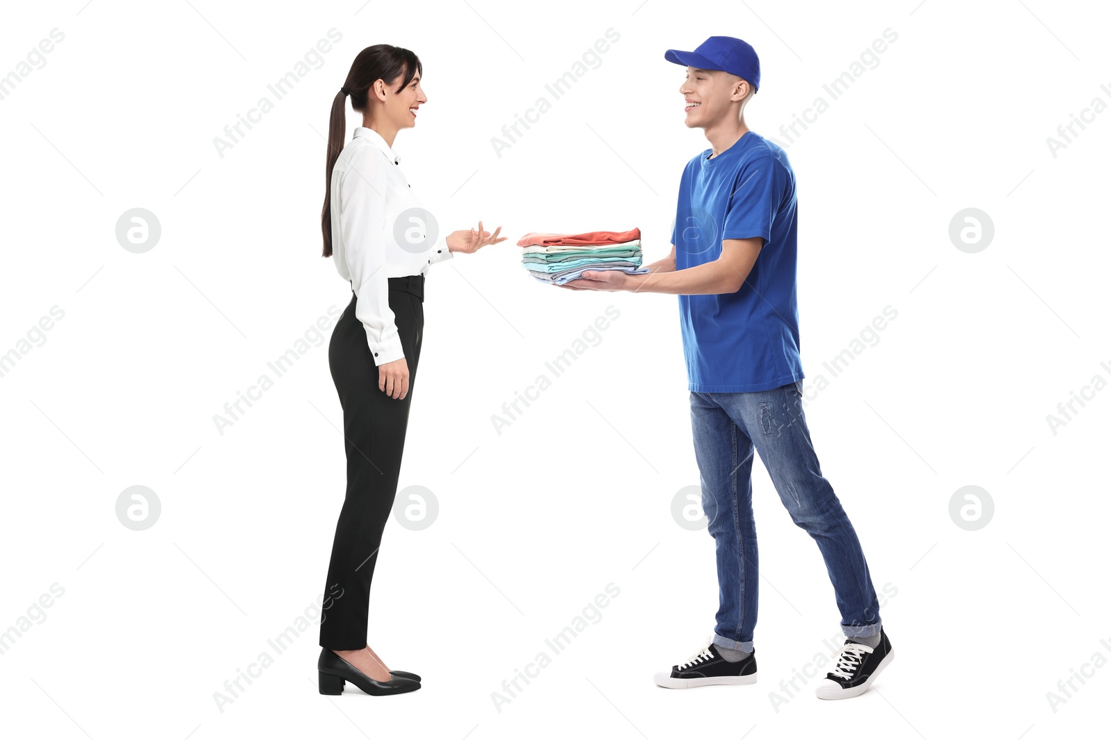 Image of Dry-cleaning delivery. Courier giving folded clothes to woman on white background