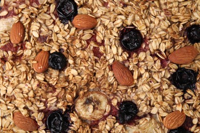 Tasty baked oatmeal with berries and almonds as background, top view