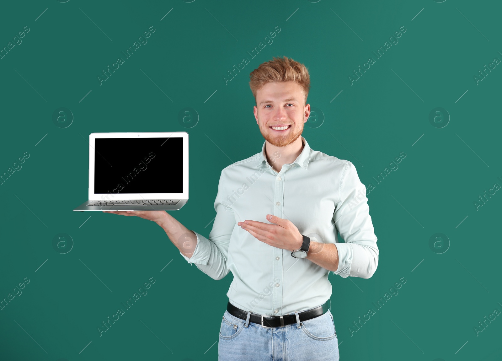 Photo of Happy man with laptop on green background. Space for text