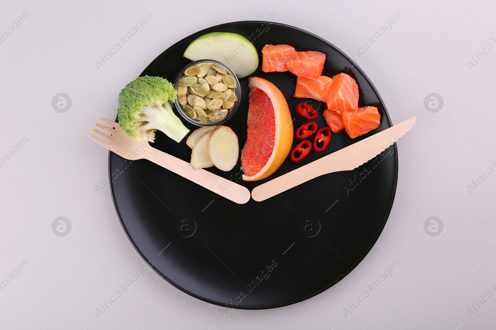 Photo of Metabolism. Plate with different food products and wooden cutlery on light background, top view