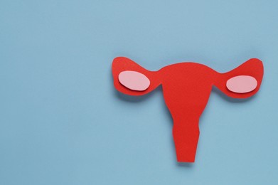 Woman's health. Paper uterus on light blue background, flat lay with space for text