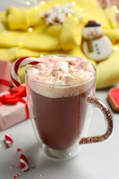 Composition with delicious marshmallow drink, festive items and yellow sweater on light table