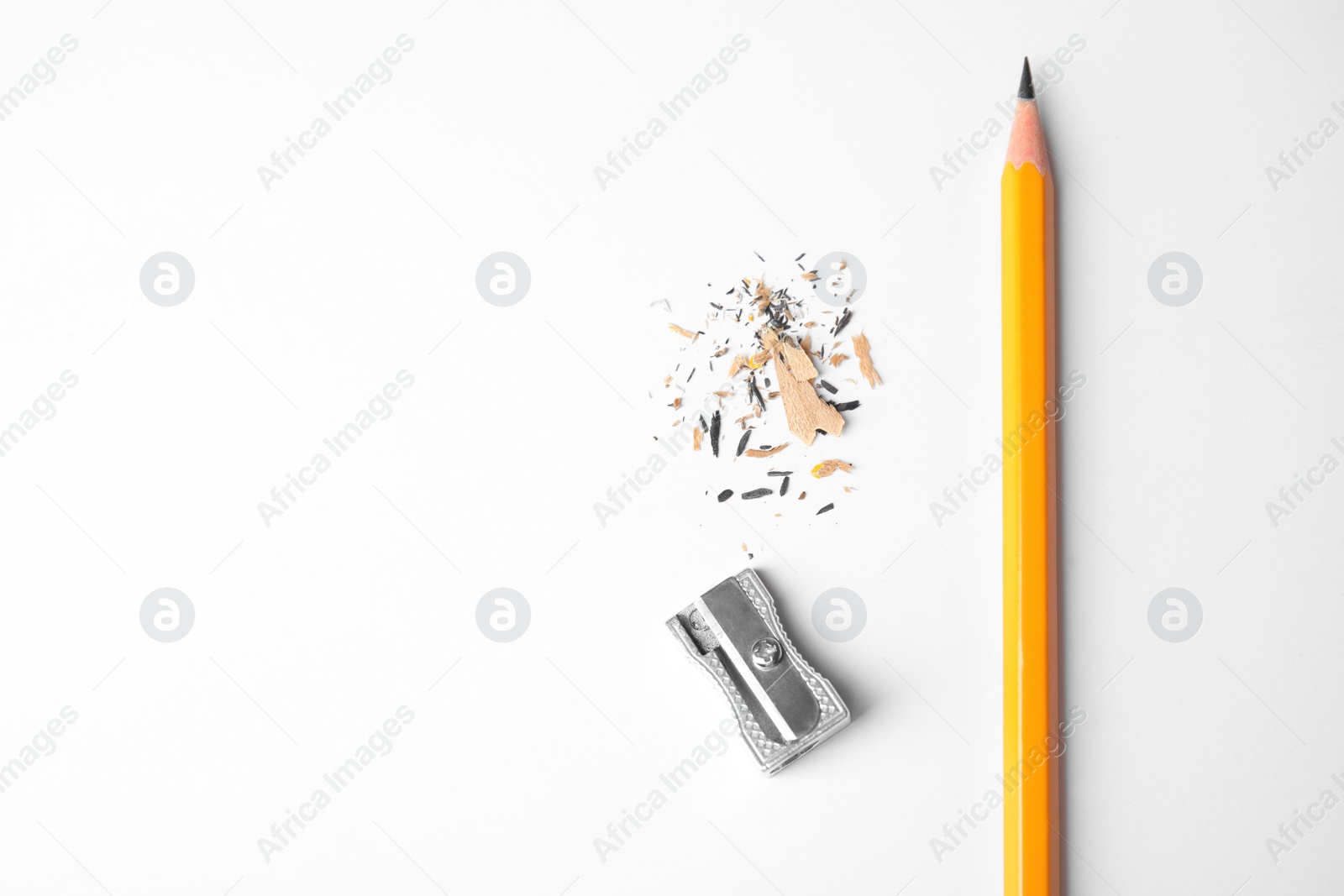 Photo of Pencil, sharpener and shavings on white background, top view