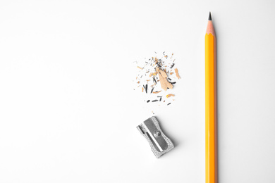 Photo of Pencil, sharpener and shavings on white background, top view