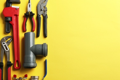 Photo of Flat lay composition with plumber's tools and space for text on color background