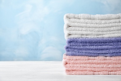 Photo of Stack of soft bath towels on table. Space for text