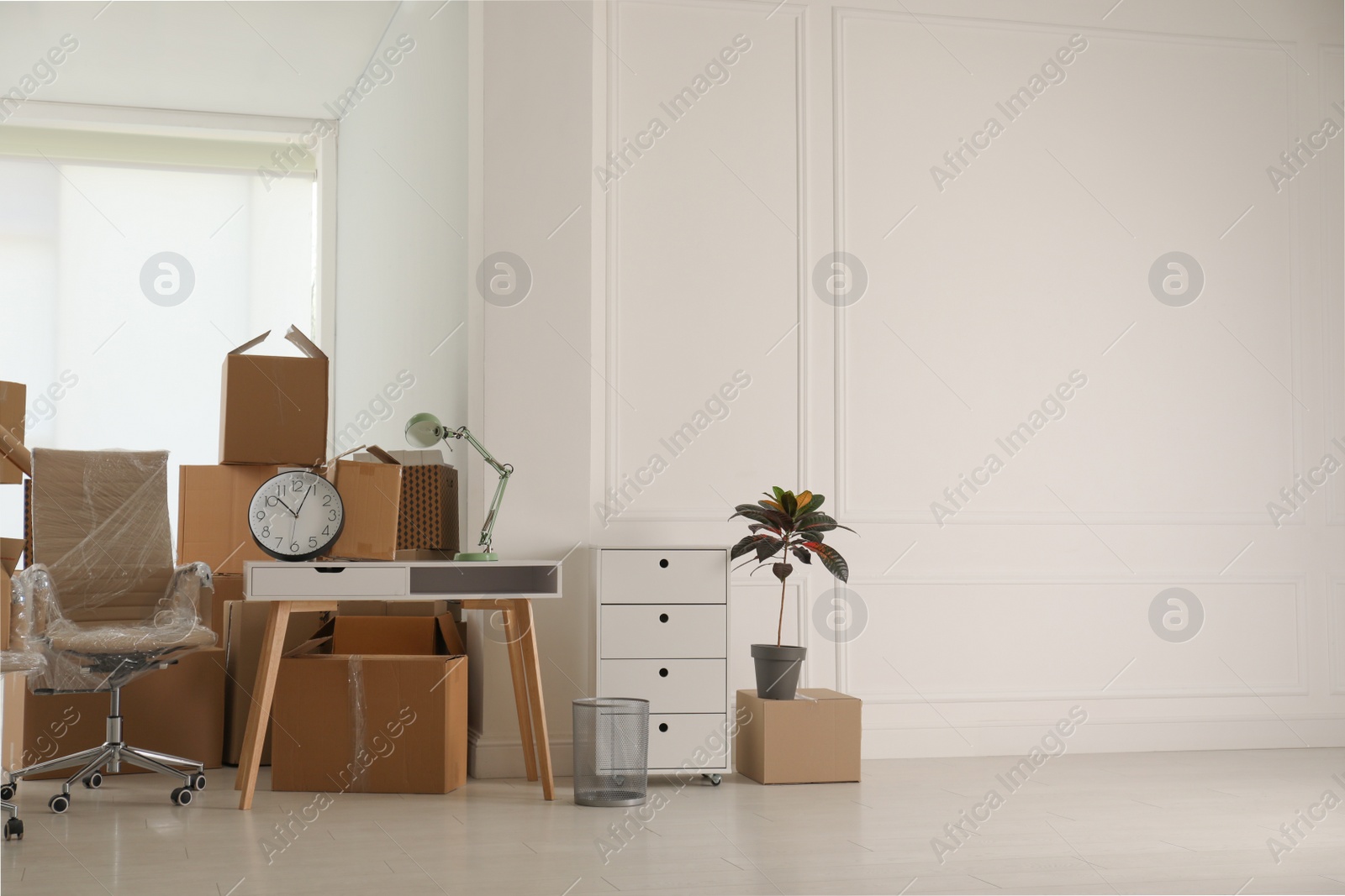 Photo of Cardboard boxes and packed stuff in office, space for text. Moving day