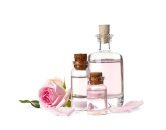 Photo of Bottles of essential oil and rose on white background