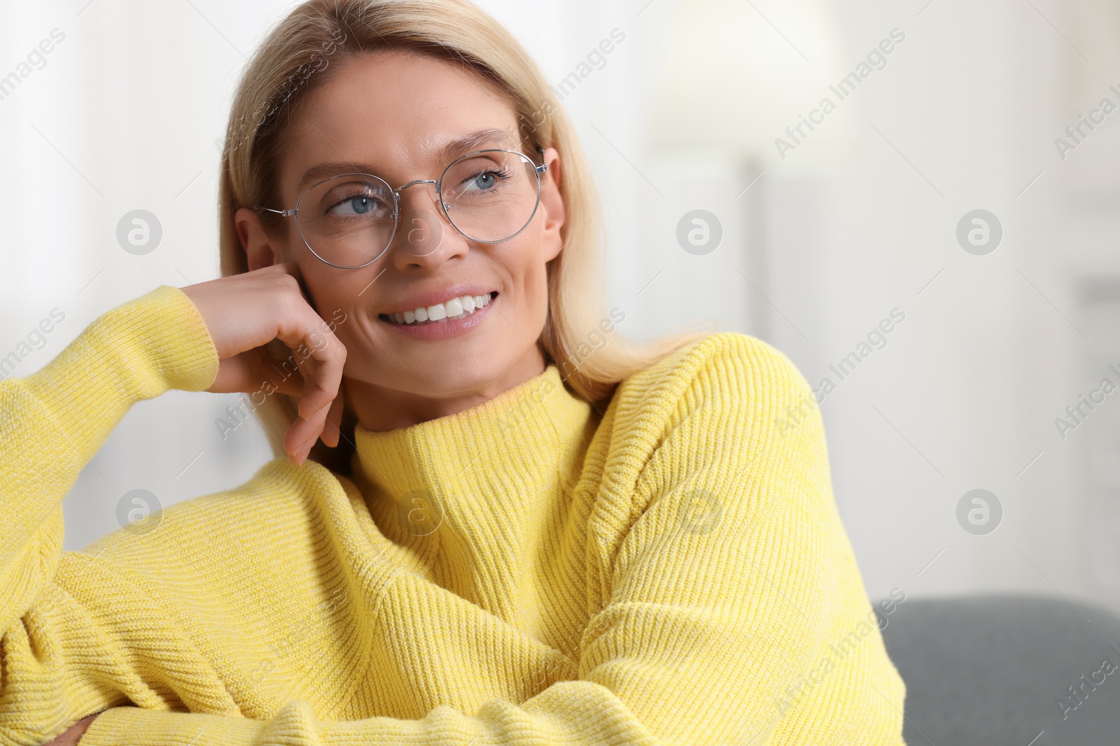 Photo of Portrait of happy woman in stylish glasses indoors. Space for text