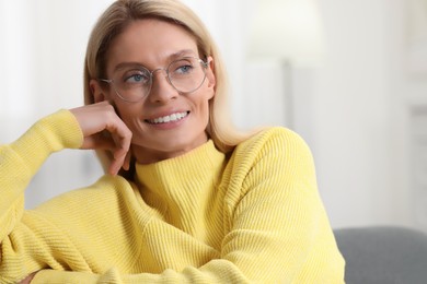 Portrait of happy woman in stylish glasses indoors. Space for text