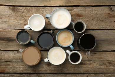 Photo of Different coffee drinks in cups on wooden table, flat lay