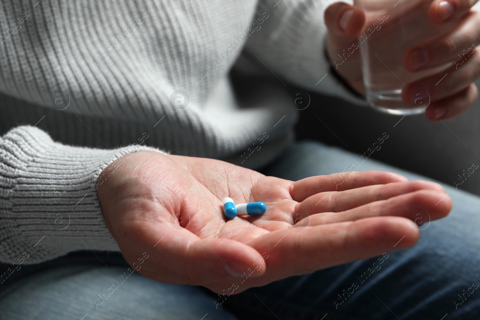 Photo of Man with glass of water and pills, closeup