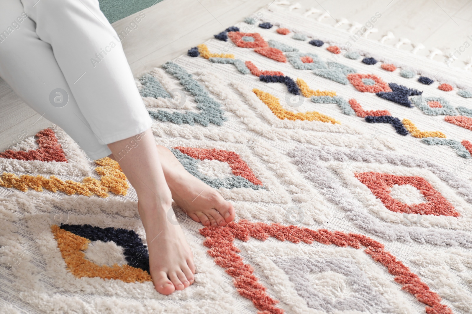 Photo of Woman on carpet with pattern at home, closeup. Space for text