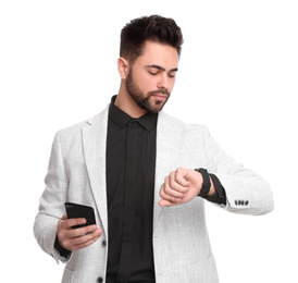 Photo of Young businessman with smartphone checking time on white background