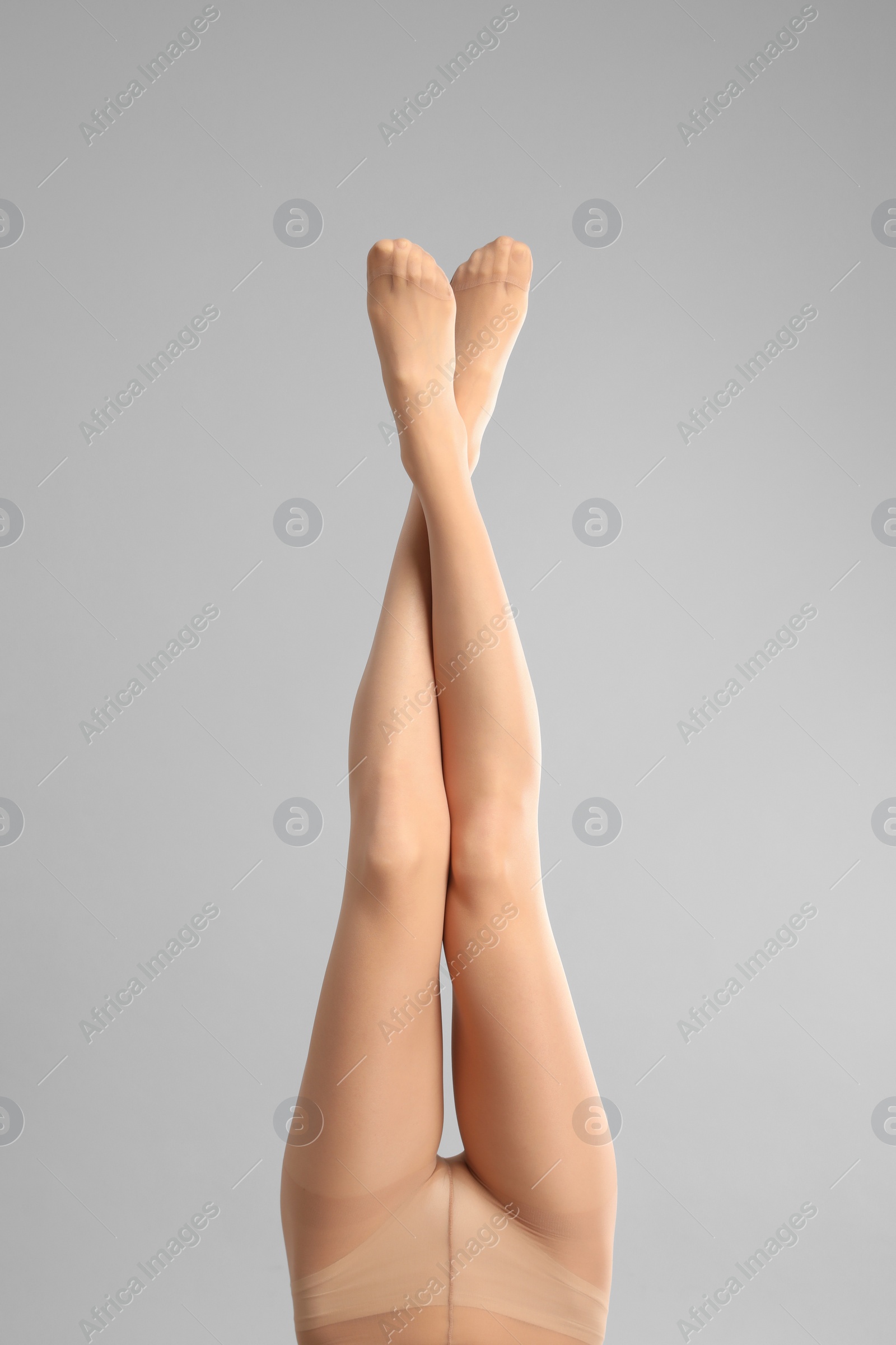 Photo of Woman wearing tights on light grey background, closeup of legs