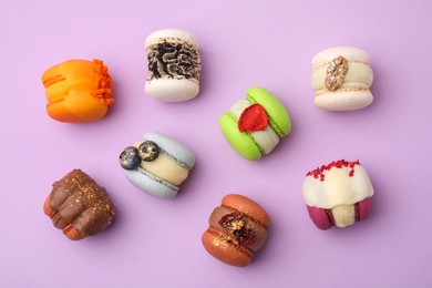 Photo of Delicious macarons on violet table, flat lay