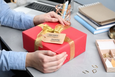 Photo of Man with present from secret Santa at workplace, closeup