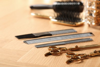 Photo of Hairdresser tools. Different scissors and combs on wooden table, closeup