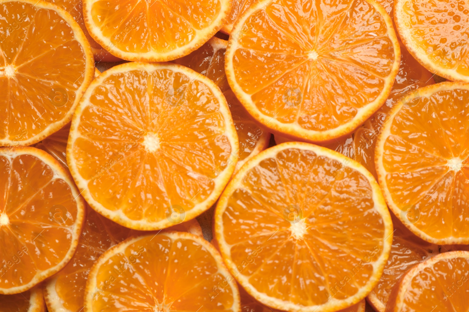 Photo of Slices of fresh ripe tangerines as background, top view. Citrus fruit