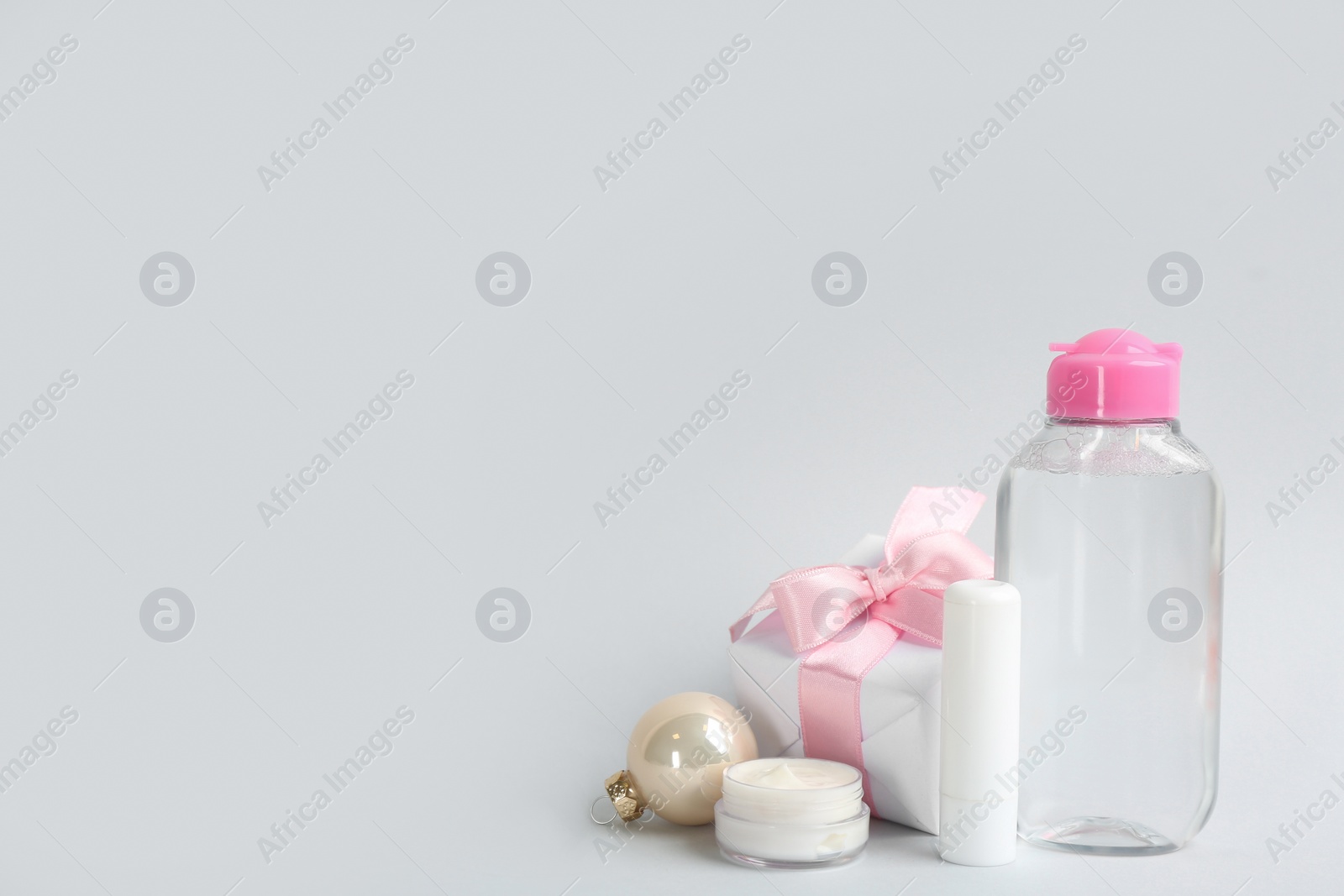 Photo of Beautiful composition with cosmetic products on light grey background, space for text. Winter care