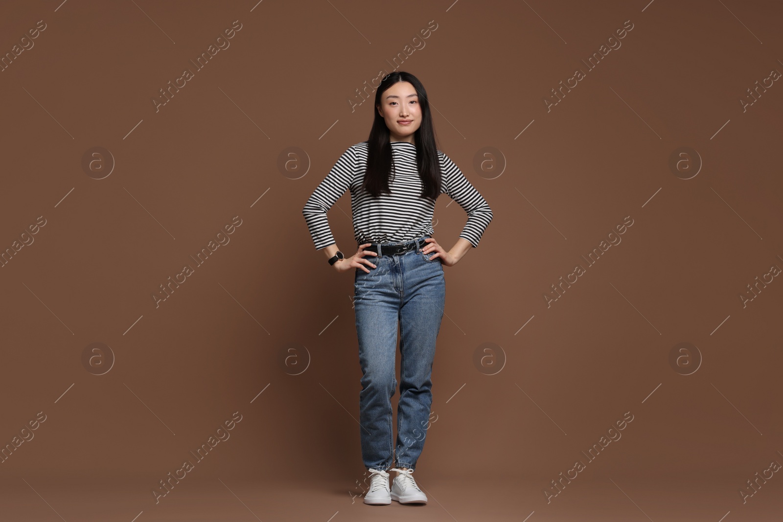 Photo of Full length portrait of beautiful woman on brown background