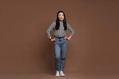 Full length portrait of beautiful woman on brown background