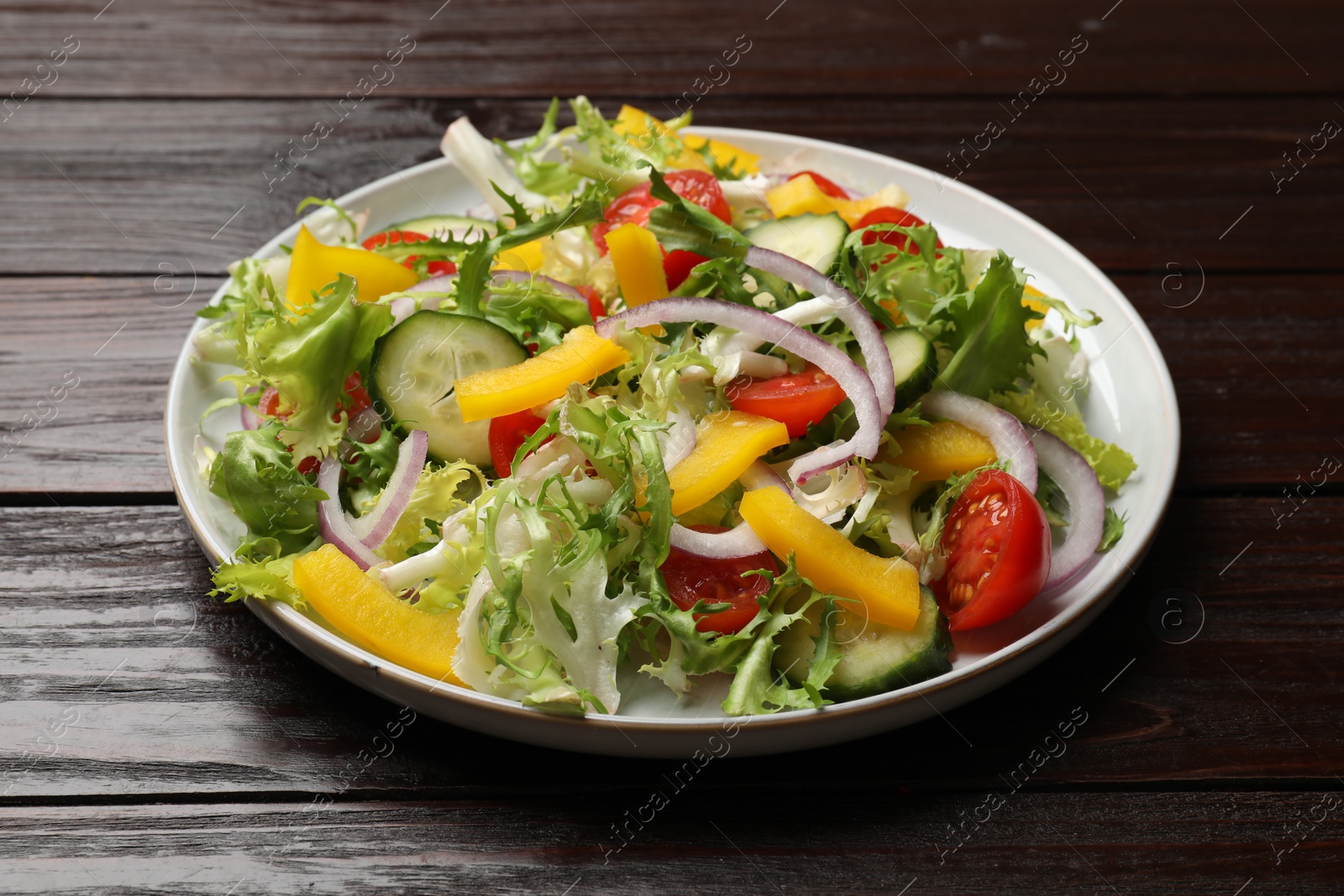 Photo of Tasty fresh vegetarian salad on dark wooden table, closeup