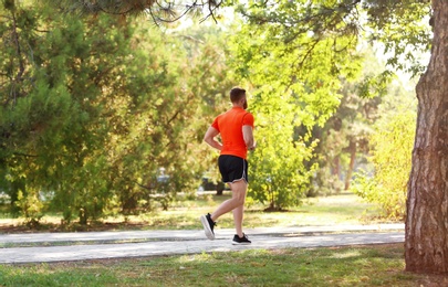 Young man running in park on sunny day