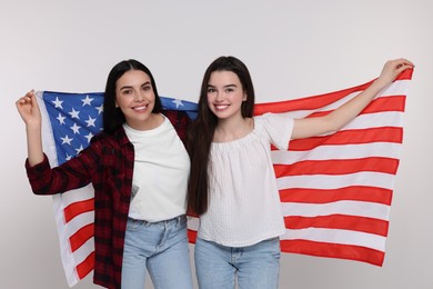 Photo of 4th of July - Independence Day of USA. Happy woman and her daughter with American flag on white background