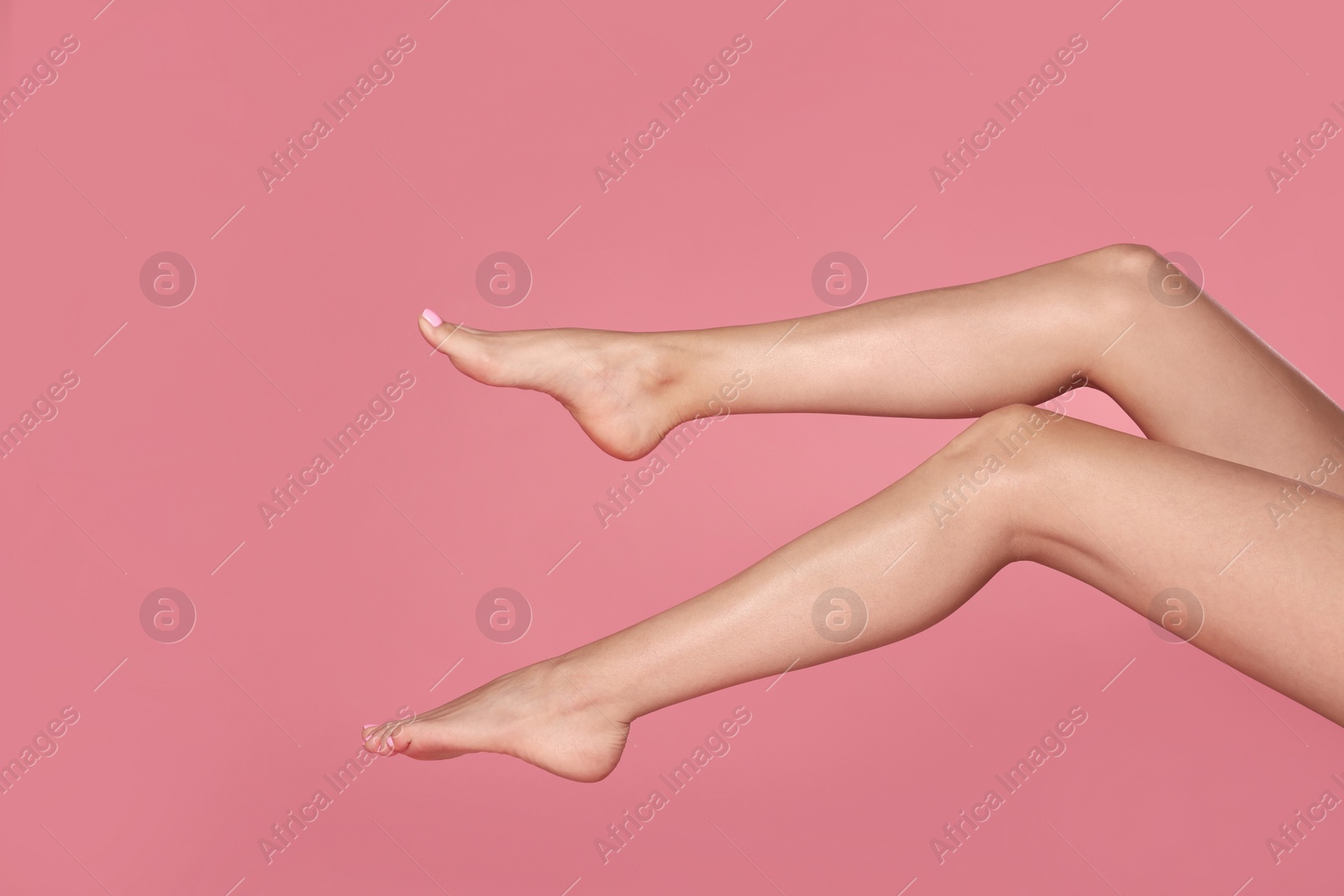 Photo of Woman with beautiful long legs on pink background, closeup