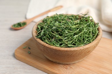 Aromatic thyme in bowl on white wooden table, closeup