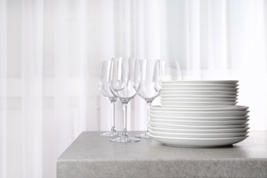 Photo of Set of clean dishes on table against blurred background. Space for text