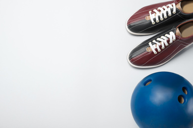 Bowling ball and shoes on white background, above view