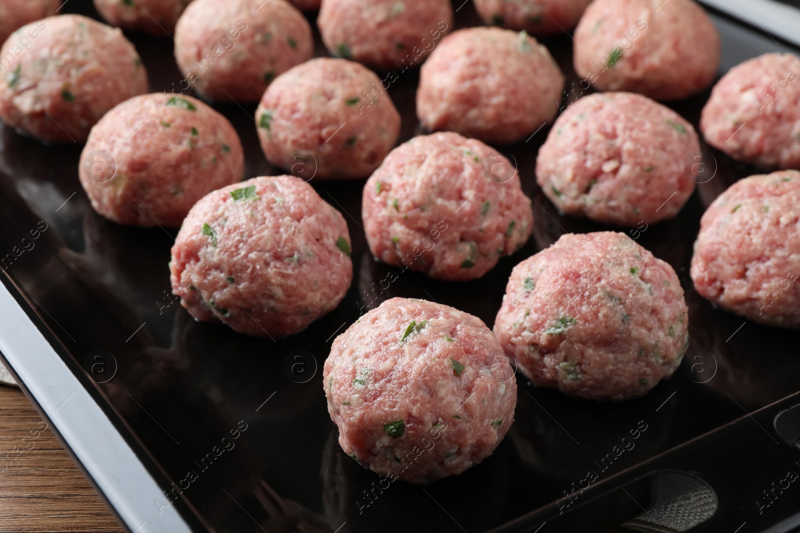 Photo of Many fresh raw meatballs in baking dish, closeup