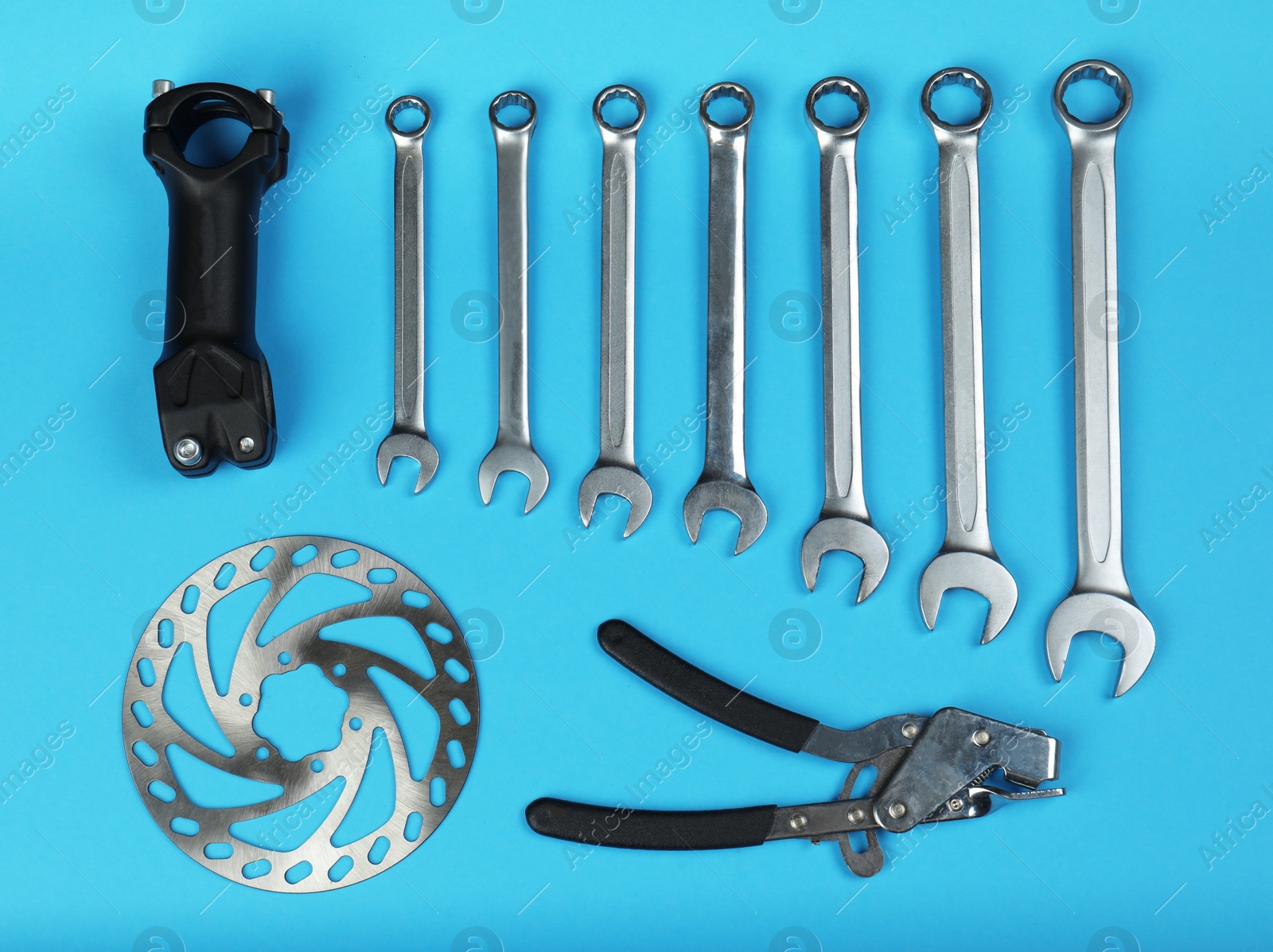 Photo of Set of different bicycle tools and parts on color background, flat lay