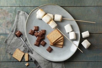 Ingredients for delicious sandwich with roasted marshmallows and chocolate on grey wooden table, flat lay