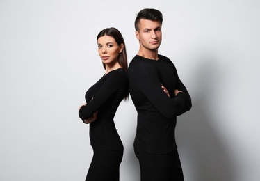 Couple wearing thermal underwear on light grey background