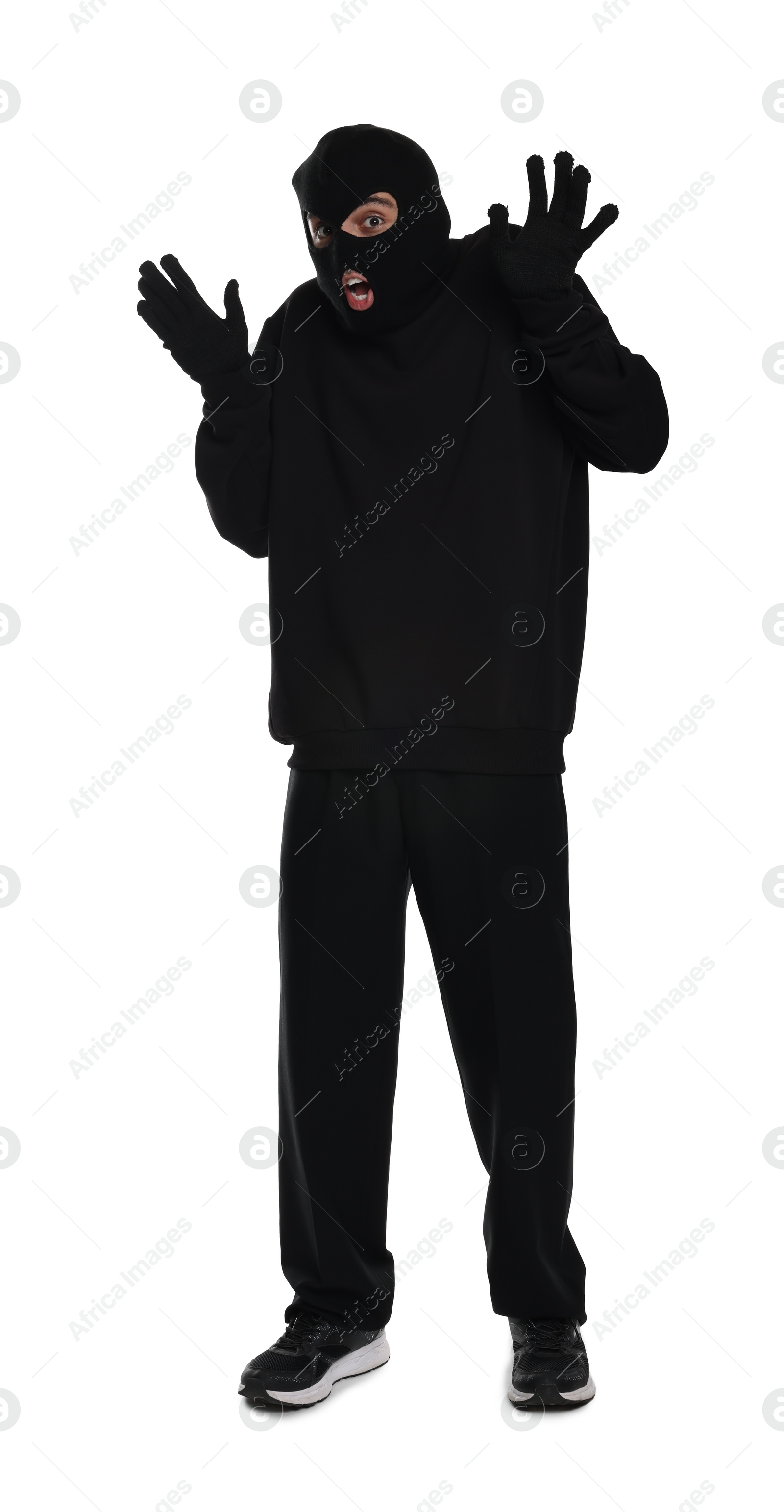 Photo of Emotional thief in balaclava raising hands on white background