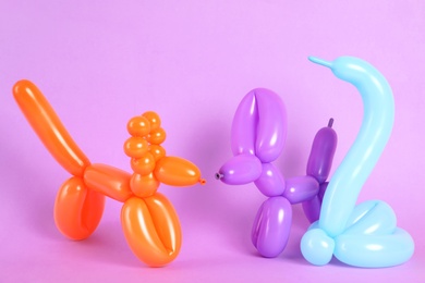 Animal figures made of modelling balloons on color background