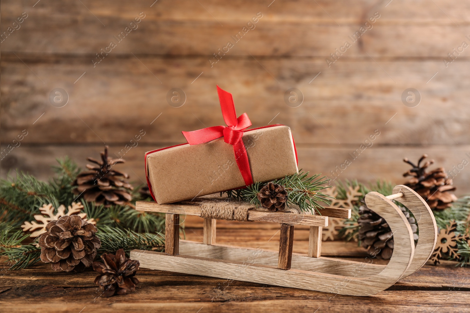 Photo of Beautiful Christmas composition with miniature sleigh on wooden table