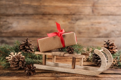Photo of Beautiful Christmas composition with miniature sleigh on wooden table