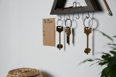 Photo of Wooden key holder and to do list on light grey wall indoors. Space for text